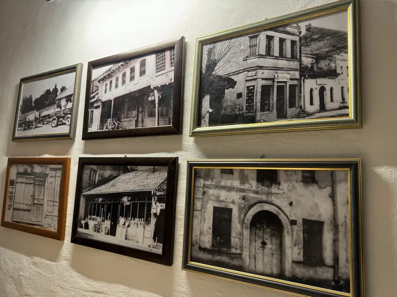 Framed black-and-white photographs of old town houses on the restaurant wall