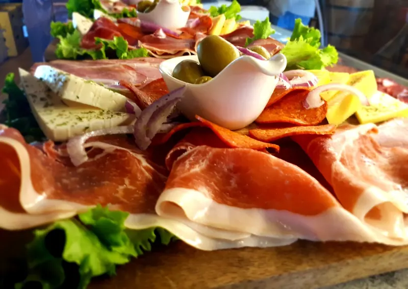 A board of prosciutto, cheeses and olives