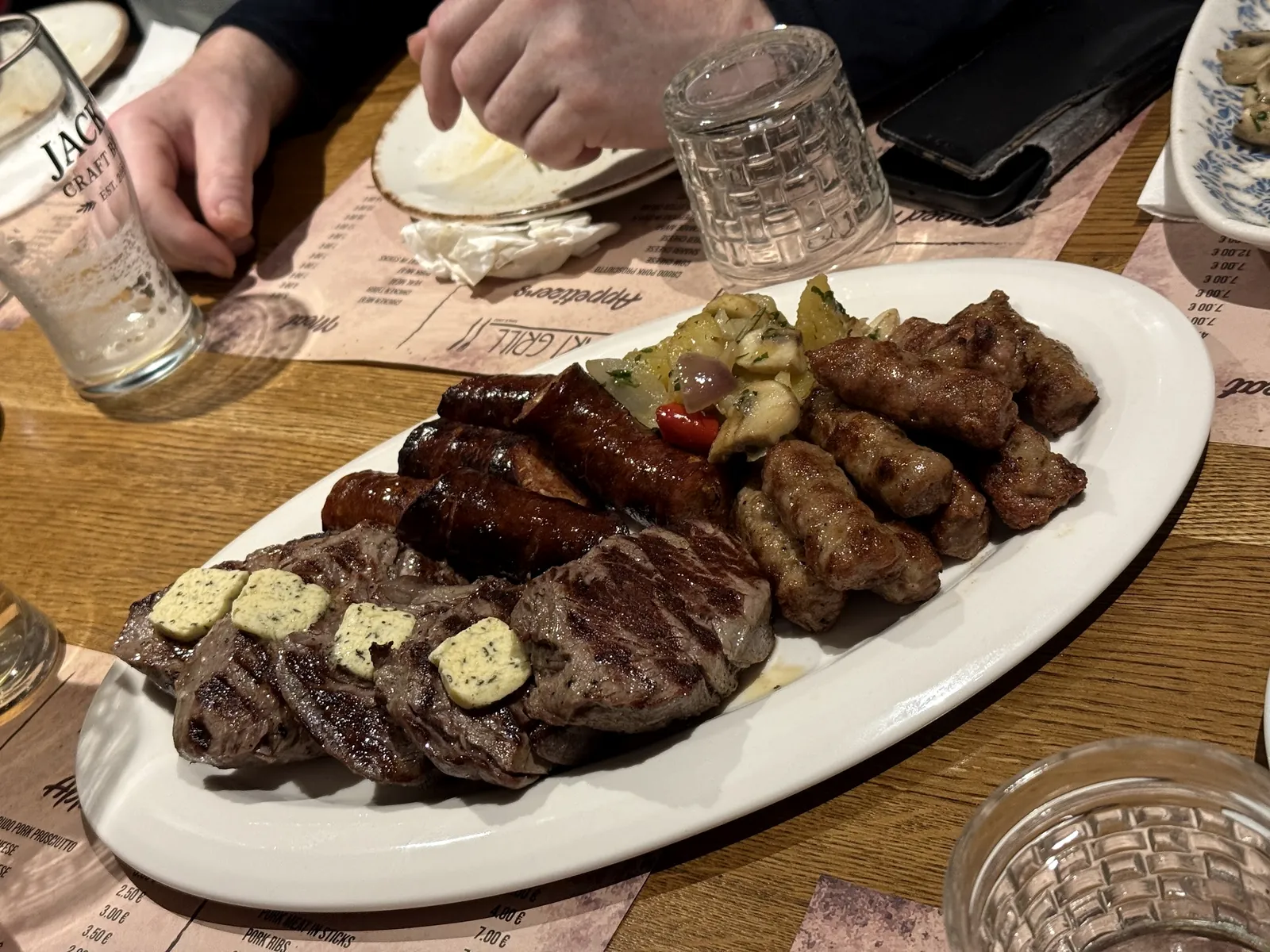A grill platter of steaks with herb butter, sausages and qebapa