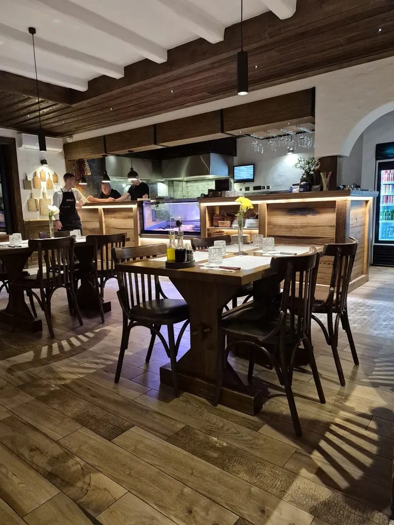 The dining room facing the open kitchen, with staff at work behind the counter